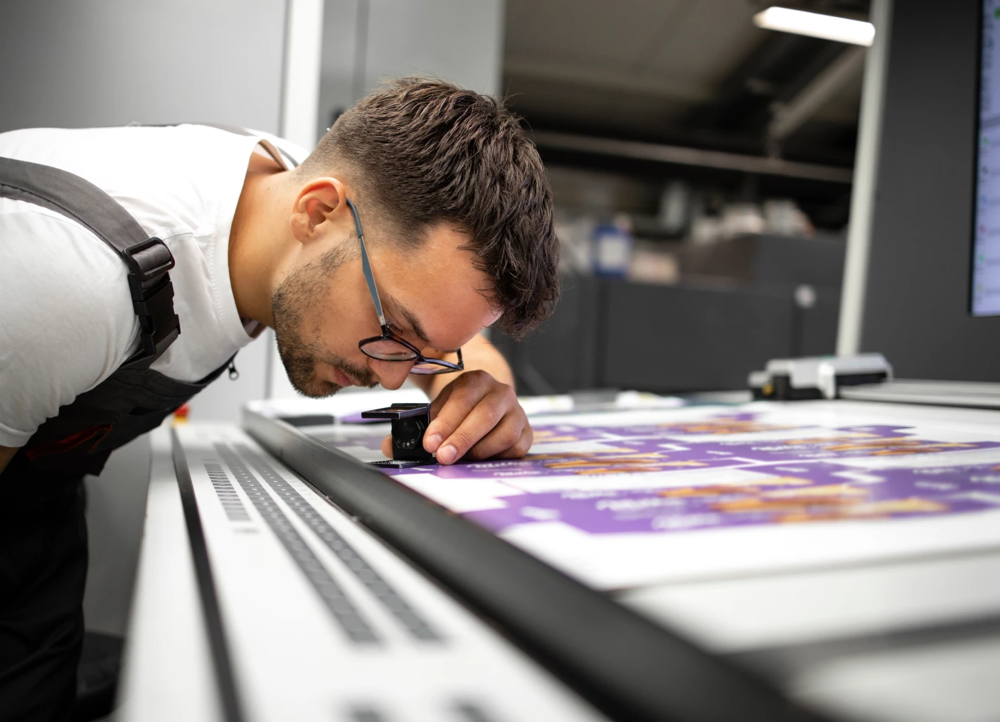Man checking print quality with loupe